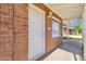 Cozy covered entryway features a secure white door, classic brick accents, and a welcoming outdoor light fixture at 1944 W Osborn Rd, Phoenix, AZ 85015