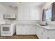 Bright kitchen featuring white appliances, white cabinets, and wood-look floors at 1944 W Osborn Rd, Phoenix, AZ 85015