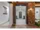 Welcoming front entrance framed by stone columns, featuring a decorative door, sconce lighting, and neutral finishes at 20165 E Via Del Palo Dr, Queen Creek, AZ 85142