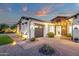 Charming single-story home featuring stone accents, lush lawn, manicured landscaping, and a two-car garage at 20165 E Via Del Palo Dr, Queen Creek, AZ 85142