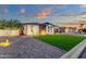 Well-maintained single-story home featuring stone accents, lush lawn, manicured landscaping, and a two-car garage at 20165 E Via Del Palo Dr, Queen Creek, AZ 85142