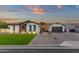 Charming single-story home featuring stone accents, lush lawn, manicured landscaping, and a two-car garage at 20165 E Via Del Palo Dr, Queen Creek, AZ 85142