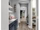 Hallway with a view to the pantry, decorative shelves, and wood-style floors at 20165 E Via Del Palo Dr, Queen Creek, AZ 85142