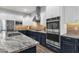 Kitchen with granite counters, stainless steel appliances, and a view of a modern range hood at 20165 E Via Del Palo Dr, Queen Creek, AZ 85142
