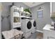 Functional laundry room with front-load washer/dryer, storage shelves, and window at 20165 E Via Del Palo Dr, Queen Creek, AZ 85142
