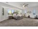 Spacious main bedroom boasts large windows, a ceiling fan, and neutral tones at 20165 E Via Del Palo Dr, Queen Creek, AZ 85142