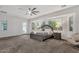 Well-lit main bedroom with large windows, ceiling fan, and wood furniture at 20165 E Via Del Palo Dr, Queen Creek, AZ 85142