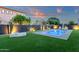 Beautiful backyard boasts a pristine pool surrounded by manicured grass and lounge seating at 20165 E Via Del Palo Dr, Queen Creek, AZ 85142