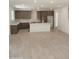 Open-concept kitchen with brown cabinets, white countertops, an island, and tile flooring throughout the room at 2469 W Rowel Rd, Phoenix, AZ 85085