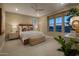 Cozy main bedroom featuring soft lighting, a ceiling fan, and large windows with picturesque views at 2476 W Rowel Rd, Phoenix, AZ 85085