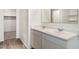 Bathroom features a double sink vanity with white cabinets and marble countertops, plus a large mirror at 25283 N 183Rd Dr, Wittmann, AZ 85361