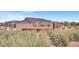 Well-maintained community entrance sign featuring native grasses and stone details at 25283 N 183Rd Dr, Wittmann, AZ 85361