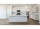 Modern kitchen featuring a large island, white cabinetry, and stainless steel appliances at 25283 N 183Rd Dr, Wittmann, AZ 85361