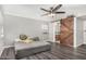 Bedroom boasts wood-look flooring, barn door to bathroom and ceiling fan at 3201 W Evans Dr, Phoenix, AZ 85053