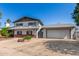 A two-story home with a wide driveway leading to an attached garage and mature trees on the property at 3201 W Evans Dr, Phoenix, AZ 85053