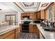 Well-lit kitchen with wooden cabinetry, white tile countertops, and modern appliances, adjacent to the dining area at 3201 W Evans Dr, Phoenix, AZ 85053