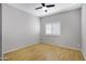 Neutral bedroom featuring wood floors, a ceiling fan, and a large window at 4207 E Rockledge Rd, Phoenix, AZ 85044