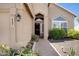 Close up of desert home's front entrance with decorative plants and a brick walkway at 4207 E Rockledge Rd, Phoenix, AZ 85044