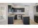 A modern kitchen featuring dark cabinetry, stainless steel appliances, and granite countertops at 4207 E Rockledge Rd, Phoenix, AZ 85044