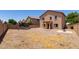 Expansive backyard featuring a covered patio, a trampoline, and a neutral-toned landscape at 44175 W Knauss Dr, Maricopa, AZ 85138
