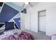 Charming bedroom with blue geometric accent wall, neutral carpet and a view to a closet at 44175 W Knauss Dr, Maricopa, AZ 85138