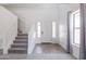 Bright foyer with staircase, neutral tile flooring and ample natural light from the sidelight windows at 44175 W Knauss Dr, Maricopa, AZ 85138