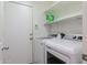 Clean laundry room featuring a white washer and dryer, white door, and shelving at 44175 W Knauss Dr, Maricopa, AZ 85138