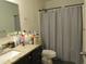 Well-lit bathroom featuring a granite countertop and shower with curtain at 4624 S 19Th Ave, Phoenix, AZ 85041