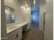 Modern bathroom with double sinks, quartz countertops, and a walk-in shower with glass door at 47230 W Cansados Rd, Maricopa, AZ 85139