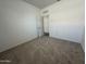 Neutral carpeted bedroom featuring white walls and a doorway leading to the hallway at 47230 W Cansados Rd, Maricopa, AZ 85139