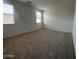 Comfortable bedroom with neutral carpet, two large windows with blinds, and ample natural light at 47230 W Cansados Rd, Maricopa, AZ 85139