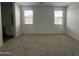 Bright bedroom with neutral carpet, two large windows with blinds, and ample natural light at 47230 W Cansados Rd, Maricopa, AZ 85139