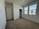 Well-lit bedroom with sliding closet doors, carpet flooring and large windows at 47230 W Cansados Rd, Maricopa, AZ 85139