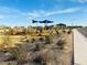 Community playground with modern equipment and lush desert landscaping near the street at 47230 W Cansados Rd, Maricopa, AZ 85139