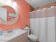 Stylish bathroom with a round mirror, a white vanity, decorative paint, and a shower with white curtains at 5517 W Commonwealth Pl, Chandler, AZ 85226