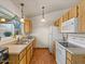 Bright kitchen with white appliances, wooden cabinets, and lots of natural light at 5517 W Commonwealth Pl, Chandler, AZ 85226