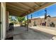 Relaxing covered patio with a charming fountain and seating area, surrounded by lush landscaping and privacy walls at 6018 W Villa Maria Dr, Glendale, AZ 85308