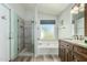 Modern bathroom featuring a walk-in shower, soaking tub, and vanity with cabinets at 6018 W Villa Maria Dr, Glendale, AZ 85308
