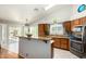 Bright kitchen with stainless appliances, granite countertops, wood cabinets, breakfast bar, and access to the backyard at 6018 W Villa Maria Dr, Glendale, AZ 85308