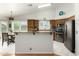 Open-concept kitchen featuring stainless steel appliances, breakfast bar, granite countertops, and wood cabinetry at 6018 W Villa Maria Dr, Glendale, AZ 85308