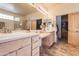 Bright bathroom featuring double vanity, soaking tub, a walk-in closet, and beautiful flooring at 6411 S River Dr # 28, Tempe, AZ 85283