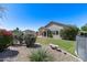 Lush backyard with a covered patio, beautiful flowers, and desert landscaping at 6742 W El Cortez Pl, Peoria, AZ 85383