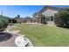 The well-maintained backyard features green grass, a seating area, outdoor kitchen, and shade at 6742 W El Cortez Pl, Peoria, AZ 85383