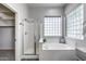 Bathroom featuring a glass shower, soaking tub with glass block window for added natural light at 6742 W El Cortez Pl, Peoria, AZ 85383