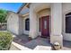 Covered entry leading to the burgundy front door, complemented by desert landscaping at 6742 W El Cortez Pl, Peoria, AZ 85383