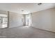 Bright living room featuring neutral carpet, chandelier, and large window at 6742 W El Cortez Pl, Peoria, AZ 85383