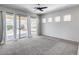 Bright living room with a ceiling fan, carpet, and large sliding doors to the backyard at 6742 W El Cortez Pl, Peoria, AZ 85383