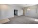 Open-concept living room with neutral walls, plush carpet, and a decorative chandelier at 6742 W El Cortez Pl, Peoria, AZ 85383