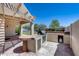 An outdoor kitchen is shaded by a pergola and has a green lawn nearby at 6742 W El Cortez Pl, Peoria, AZ 85383