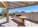 An outdoor kitchen sits under a covered patio with views of a grassy yard at 6742 W El Cortez Pl, Peoria, AZ 85383